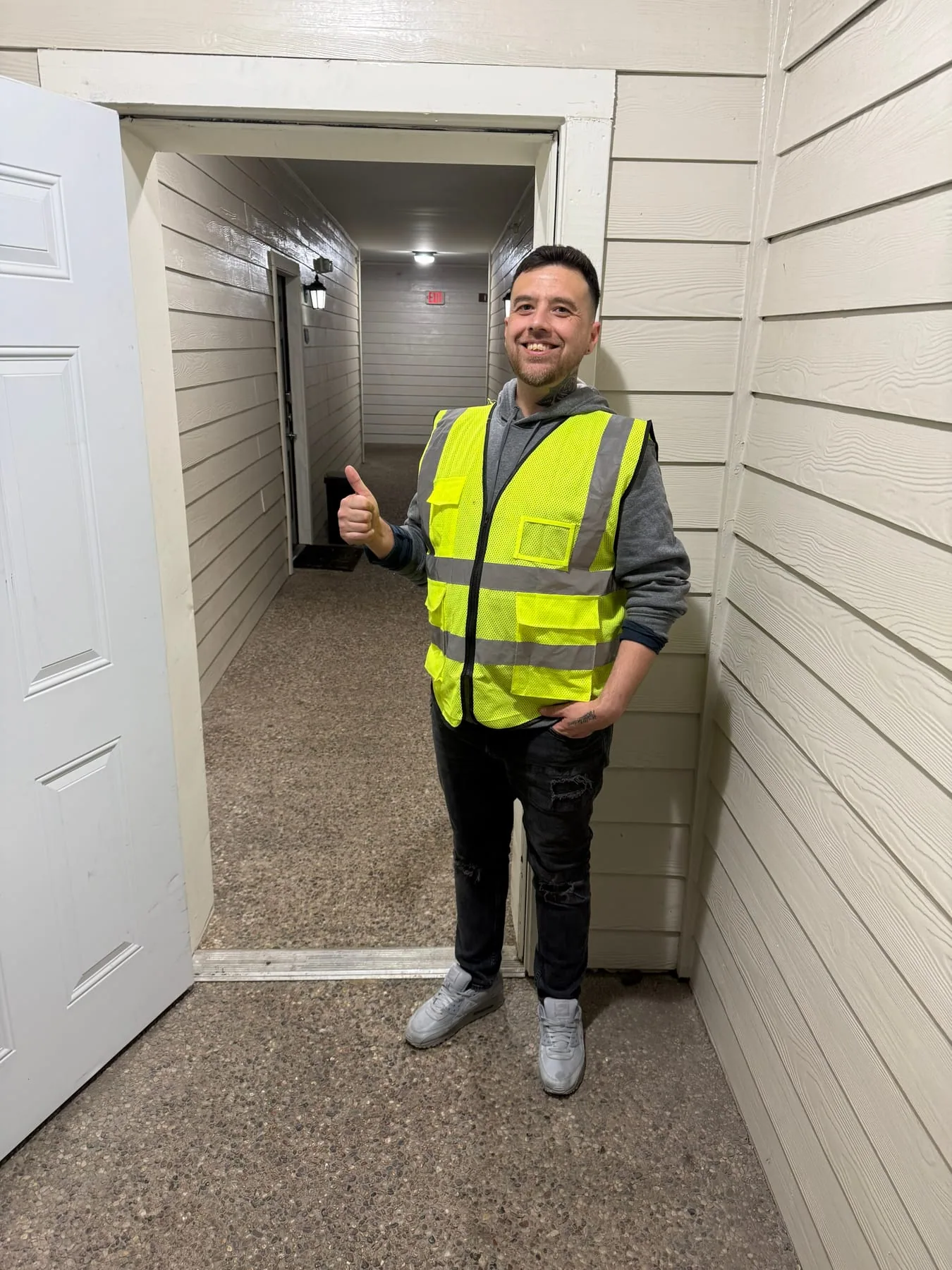 Daniel Montenegro giving a thumbs-up in an apartment breezeway